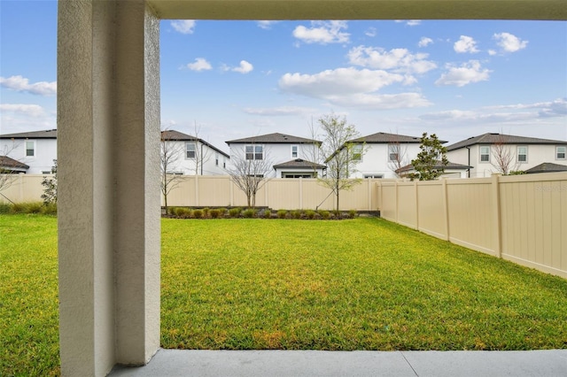 view of yard with a fenced backyard and a residential view