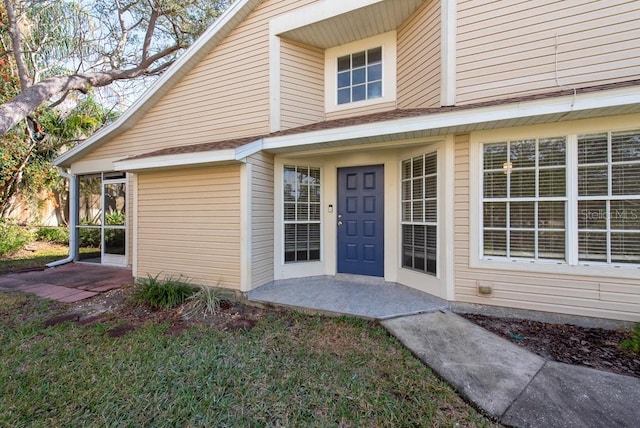 property entrance featuring a lawn