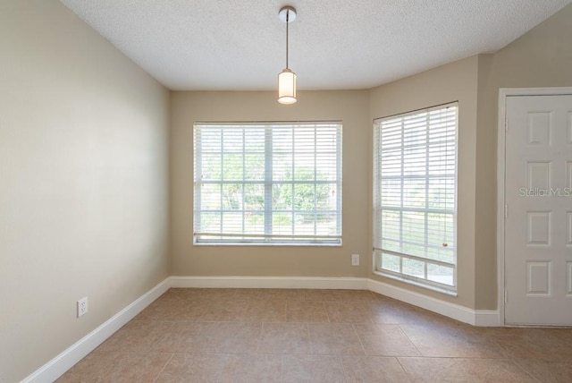 tiled spare room featuring a textured ceiling