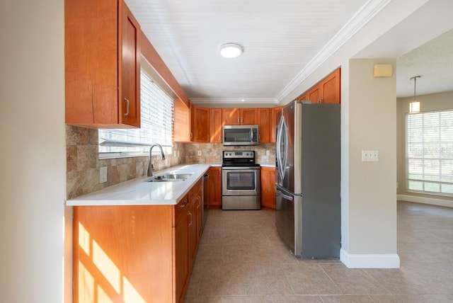 kitchen featuring sink, crown molding, backsplash, stainless steel appliances, and decorative light fixtures