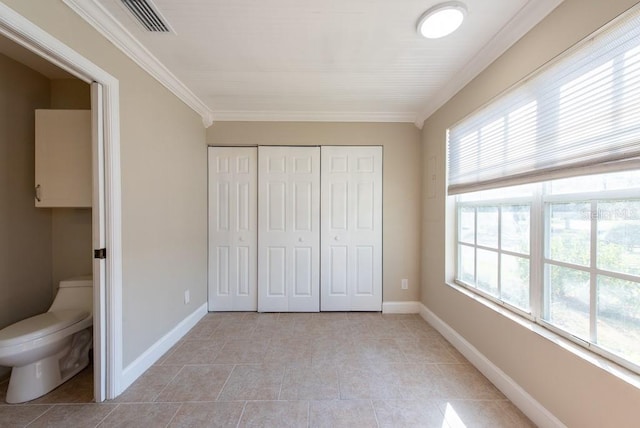 unfurnished bedroom featuring ornamental molding, light tile patterned floors, and a closet