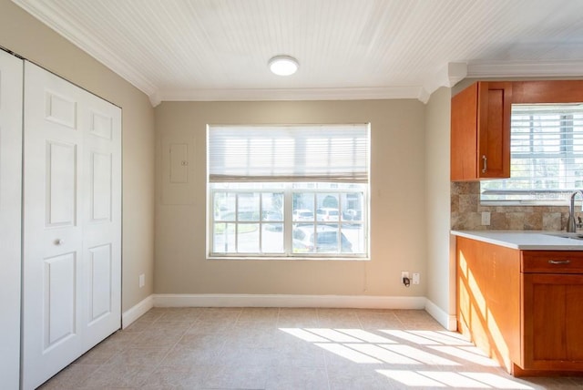 kitchen featuring light tile patterned flooring, ornamental molding, sink, and decorative backsplash