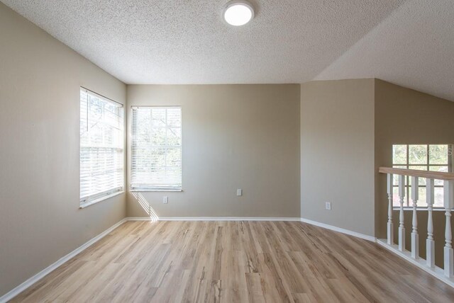 spare room featuring light hardwood / wood-style floors and a textured ceiling