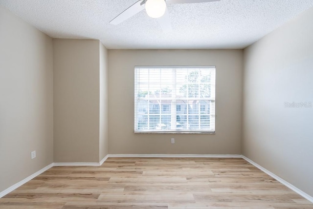 spare room featuring ceiling fan, light hardwood / wood-style flooring, and a textured ceiling