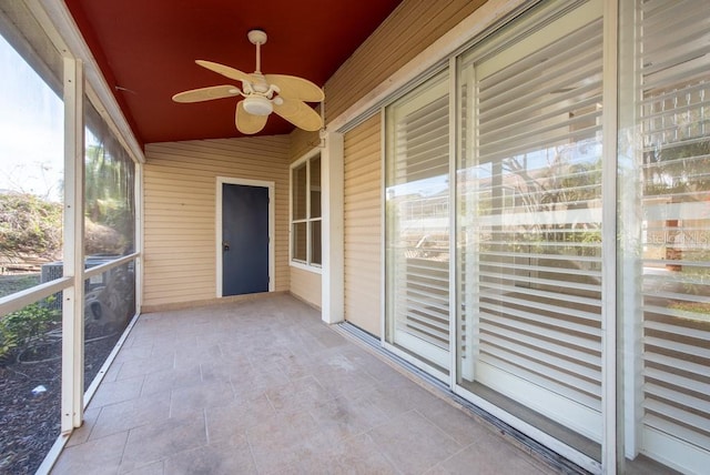 unfurnished sunroom with ceiling fan and vaulted ceiling