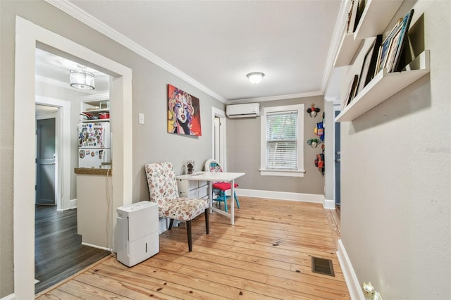 interior space featuring crown molding, a wall mounted AC, and light hardwood / wood-style flooring