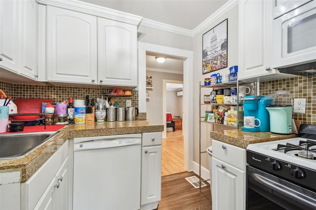 kitchen with white appliances, light hardwood / wood-style flooring, crown molding, white cabinetry, and backsplash