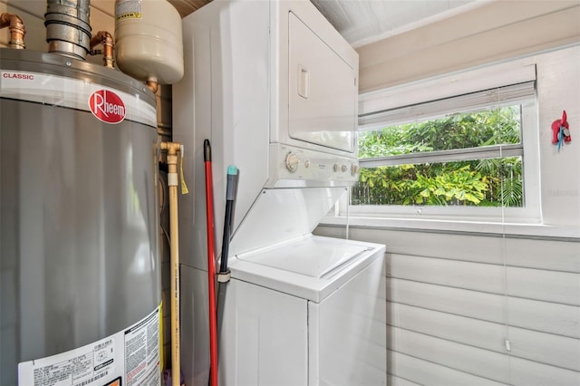 clothes washing area with water heater and stacked washer and clothes dryer