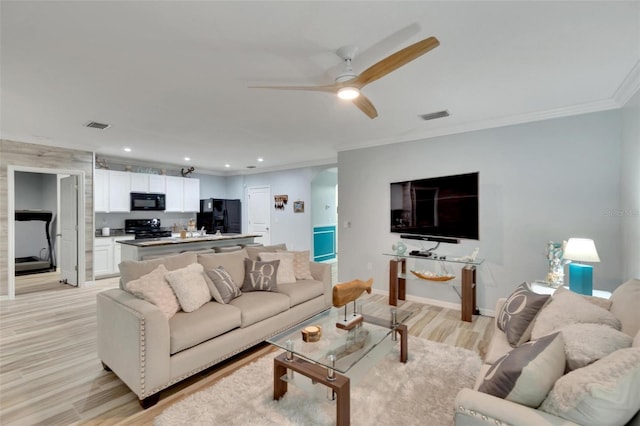 living room featuring crown molding, ceiling fan, and light hardwood / wood-style floors