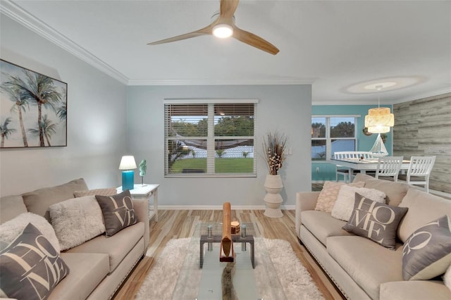 living room featuring crown molding, a wealth of natural light, and light hardwood / wood-style floors