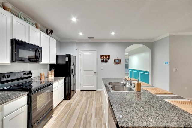 kitchen with sink, crown molding, black appliances, white cabinets, and a center island with sink