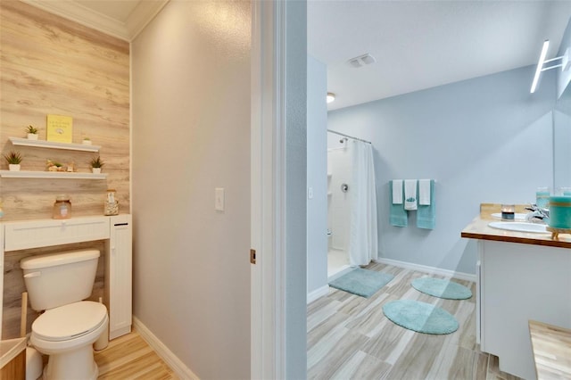 bathroom featuring toilet, vanity, wooden walls, curtained shower, and hardwood / wood-style flooring