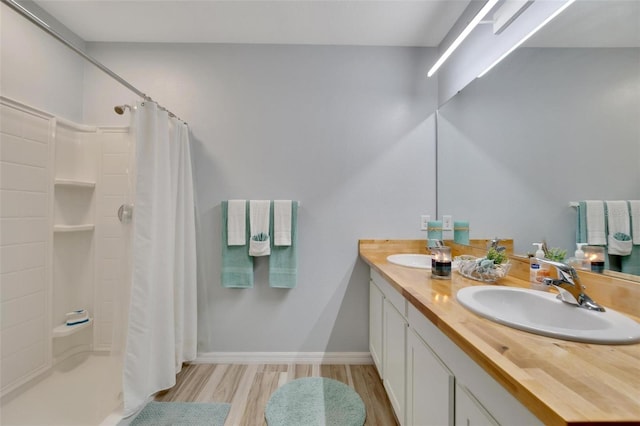 bathroom with a shower with shower curtain, vanity, and hardwood / wood-style floors