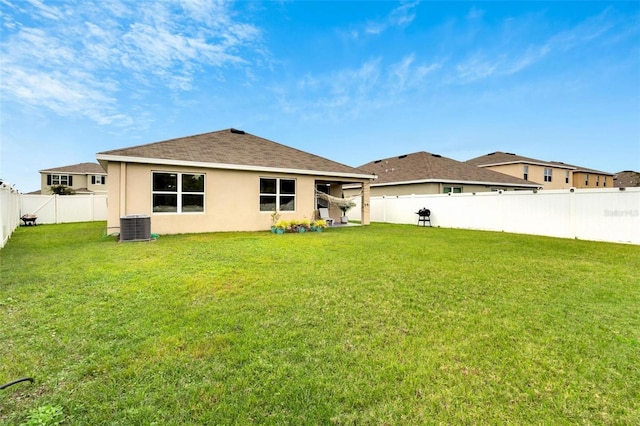 back of house featuring central AC and a lawn