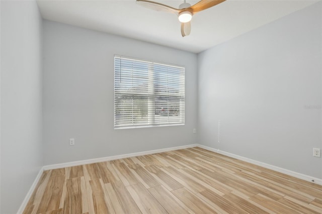 unfurnished room featuring a ceiling fan, light wood-type flooring, and baseboards