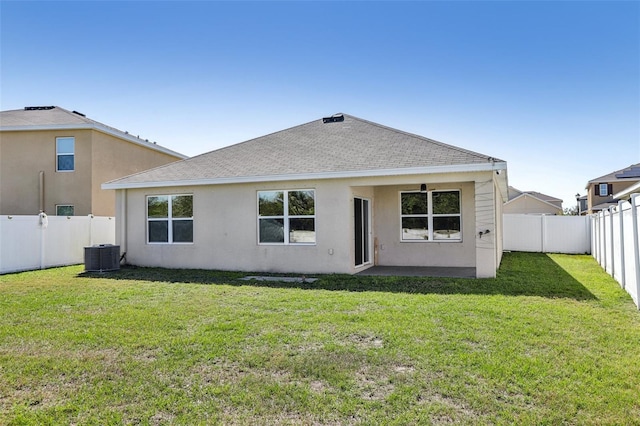 rear view of house with a fenced backyard, a lawn, and stucco siding