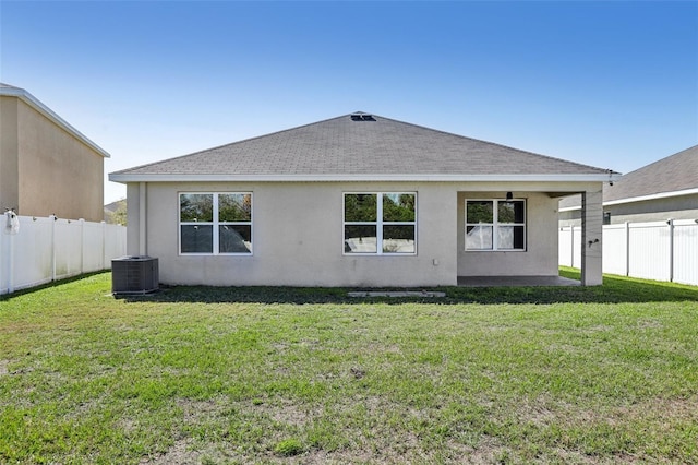 back of house featuring a shingled roof, stucco siding, cooling unit, a yard, and a fenced backyard