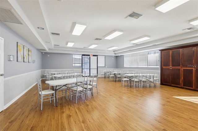 dining area with visible vents and wood finished floors