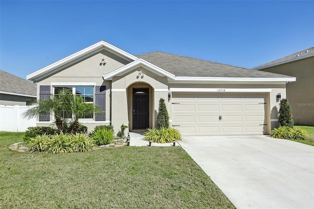 single story home with stucco siding, a front lawn, driveway, and fence