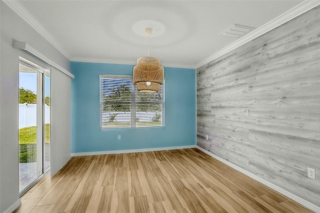 unfurnished dining area featuring visible vents, light wood-style flooring, and ornamental molding