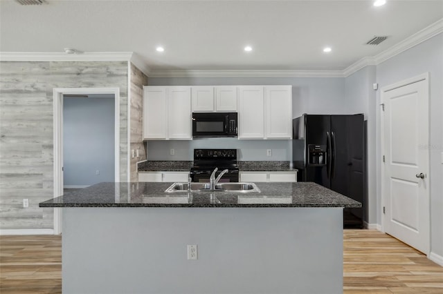 kitchen featuring visible vents, black appliances, crown molding, white cabinetry, and a sink