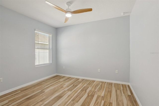 spare room with light wood finished floors, ceiling fan, and baseboards