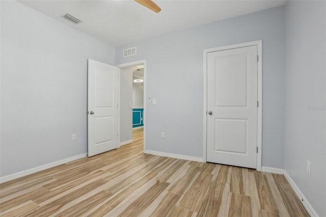 unfurnished bedroom with visible vents, baseboards, light wood-style flooring, and a ceiling fan