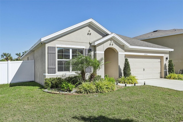 view of front of house with stucco siding, concrete driveway, a front yard, and fence