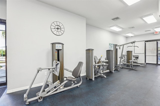 exercise room with visible vents, a healthy amount of sunlight, and baseboards