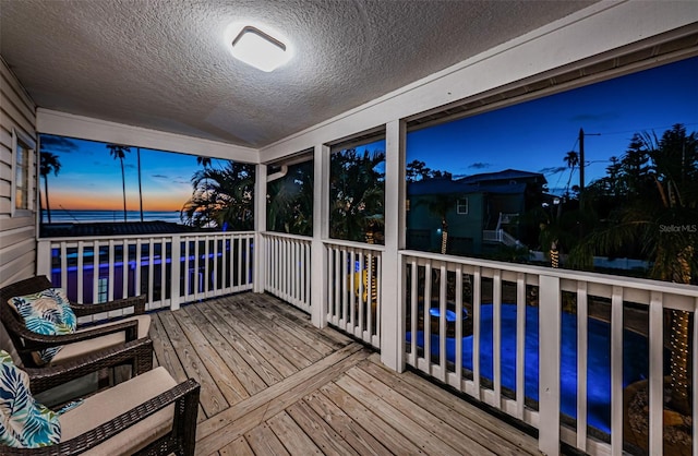 deck at dusk with a pool