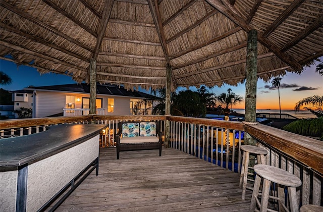 deck at dusk featuring a gazebo