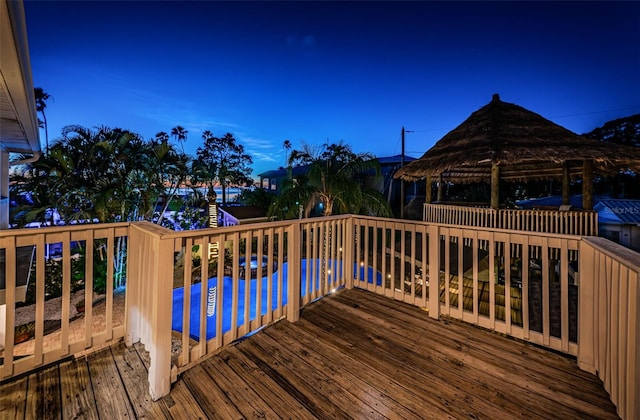 wooden terrace featuring a gazebo and a swimming pool