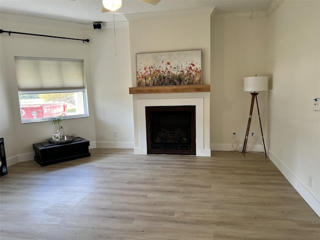 unfurnished living room with crown molding, ceiling fan, and light hardwood / wood-style floors