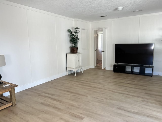 living room featuring a textured ceiling and light wood-type flooring