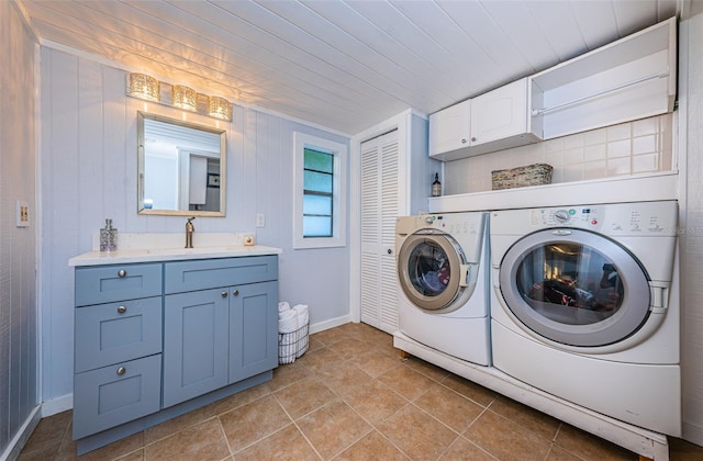 laundry area featuring sink, wood ceiling, washing machine and dryer, and cabinets