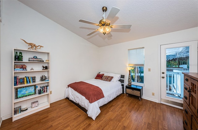 bedroom with lofted ceiling, ceiling fan, a textured ceiling, dark hardwood / wood-style flooring, and access to outside