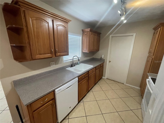 kitchen featuring sink, light tile patterned floors, and white appliances