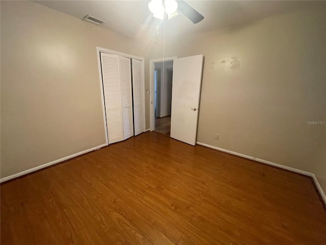 unfurnished bedroom featuring hardwood / wood-style floors, a closet, and ceiling fan