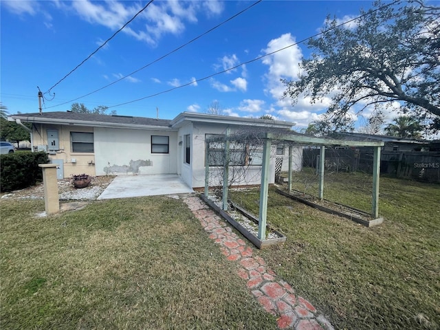 back of property with a yard and a patio area