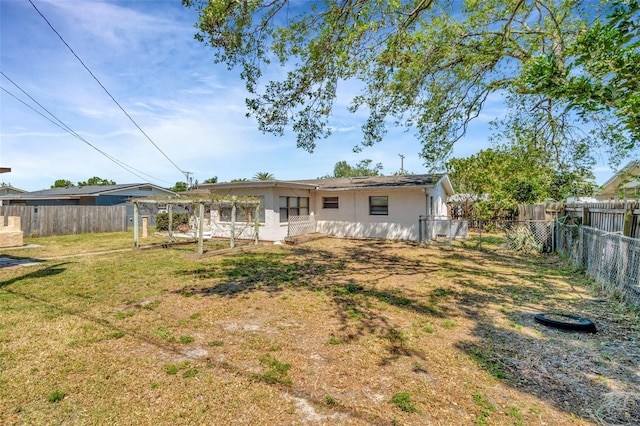 540 Florida Cir S, Apollo Beach, FL 33572 - back of house with a fenced backyard, stucco siding, and a yard
