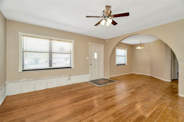 540 Florida Cir S, Apollo Beach, FL 33572 - entryway with arched walkways, baseboards, wood finished floors, and ceiling fan with notable chandelier