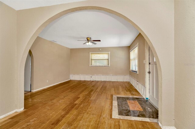 540 Florida Cir S, Apollo Beach, FL 33572 - empty room featuring wood finished floors, baseboards, visible vents, arched walkways, and ceiling fan