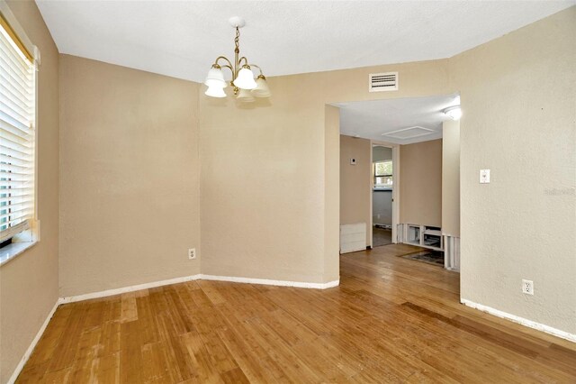540 Florida Cir S, Apollo Beach, FL 33572 - spare room with wood finished floors, a notable chandelier, baseboards, and visible vents