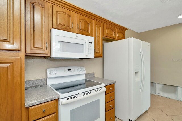 540 Florida Cir S, Apollo Beach, FL 33572 - kitchen featuring white appliances, brown cabinetry, light countertops, and light tile patterned floors