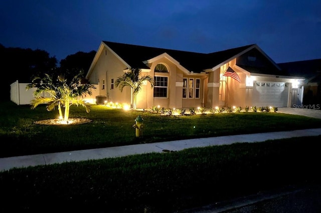 view of front of property with a garage and a lawn