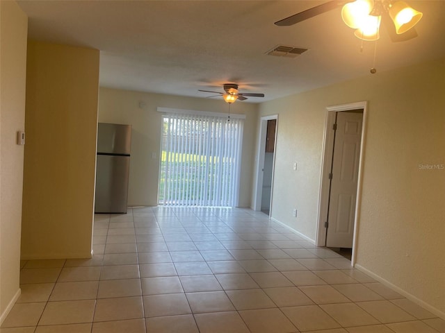 empty room featuring light tile patterned floors and ceiling fan