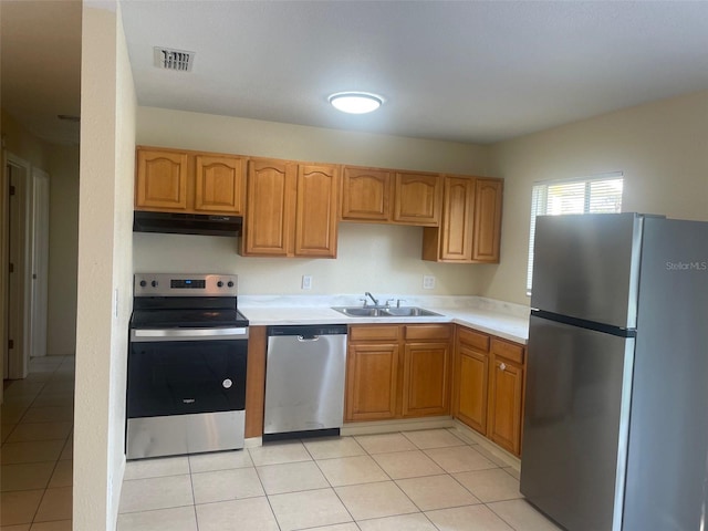 kitchen with sink, light tile patterned flooring, and appliances with stainless steel finishes