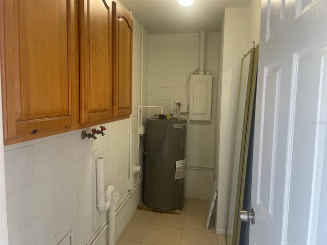 laundry room featuring tile walls, cabinets, light tile patterned floors, electric panel, and electric water heater