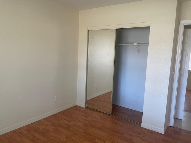 unfurnished bedroom featuring hardwood / wood-style flooring and a closet