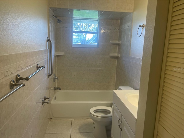 full bathroom featuring tile patterned flooring, tile walls, vanity, toilet, and tiled shower / bath